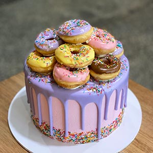 Pink cake with purple drip and donuts
